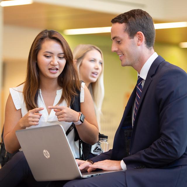 A female student points to a laptop.