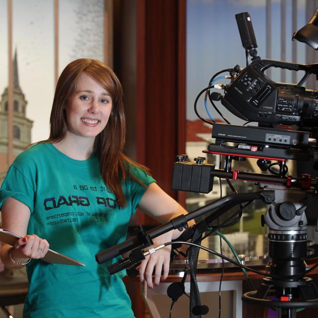 Student in FTDM studio with camera and clipboard