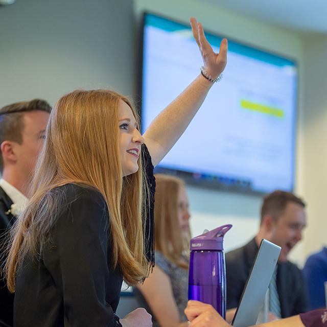 a future leader raises her hand in a Neeley classroom