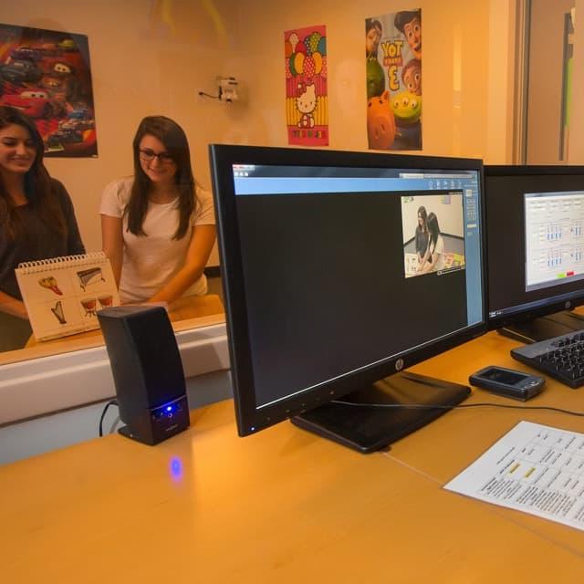 Students conduct a behavioral study of two female subjects from behind a two-way mirror